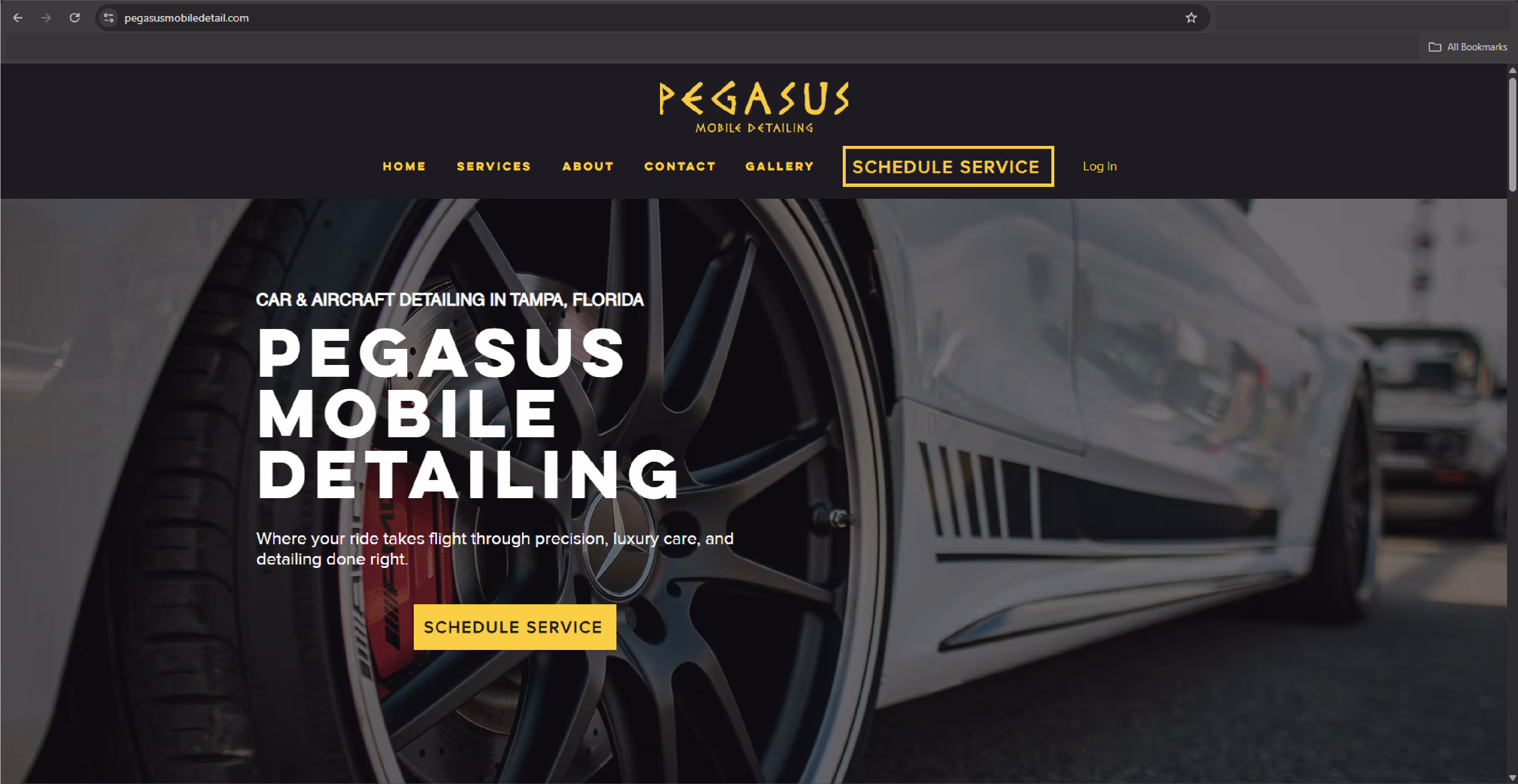 Close-up of a luxury car's black alloy wheel and brake caliper on a mobile detailing website.